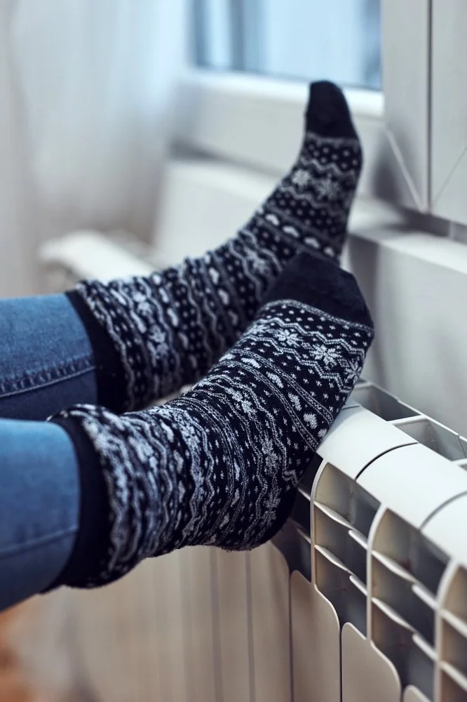 Woman,Heating,Feet,On,A,Chilly,Winter,Day,,Energy,And image about us percy rauchs 2